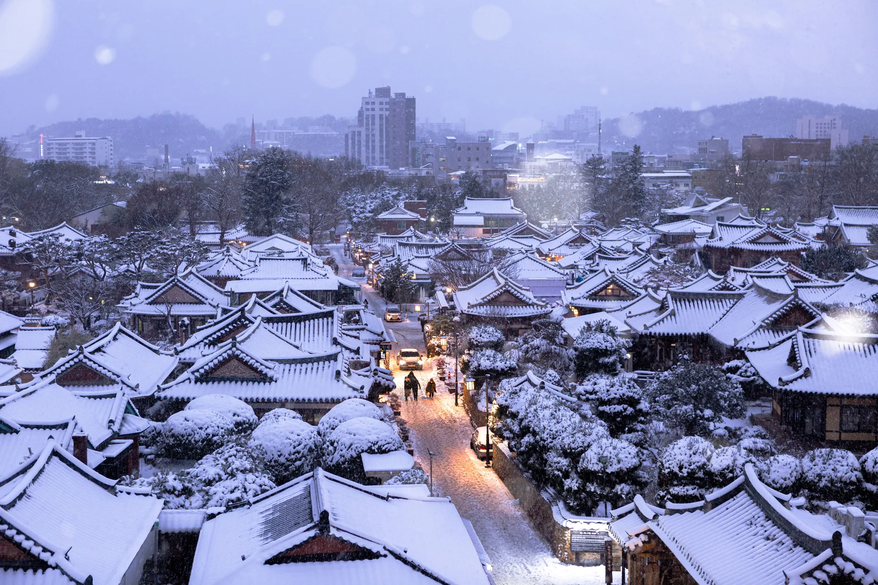 A hanok village under the first snow of the year, seen from above